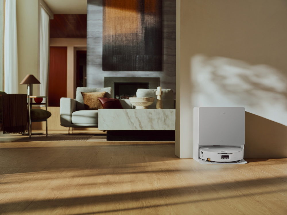 Roborock sorprende en IFA 2026 con robots para limpiar la casa, el jardín y la piscina Robot aspirador en base de carga en sala moderna y luminosa con sofá y decoración elegante.