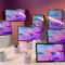 Tabletas modernas expuestas con pantalla inicial colorida, sobre superficies cilíndricas blancas y rosadas.