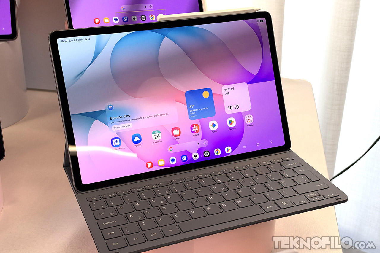 Tableta con teclado y pantalla encendida mostrando aplicaciones y widgets en un fondo morado.