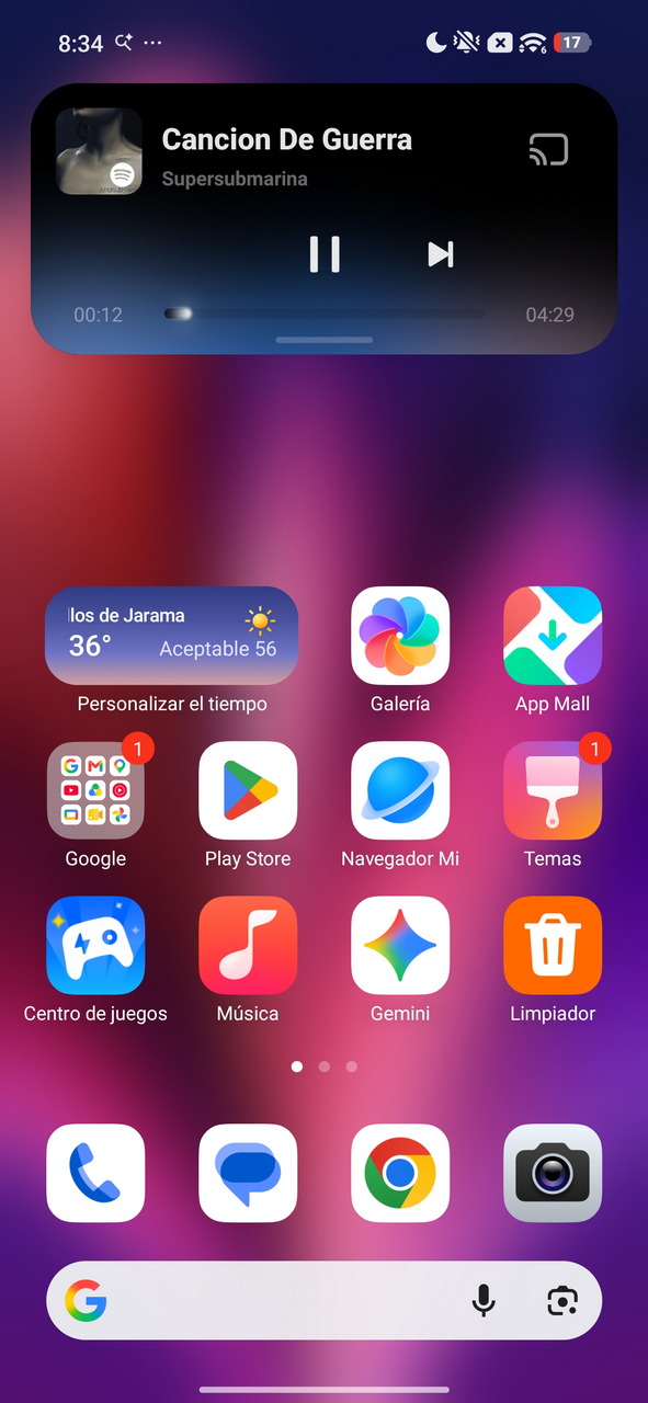 Pantalla de inicio con widgets de clima y música, mostrando Canción De Guerra de Supersubmarina.