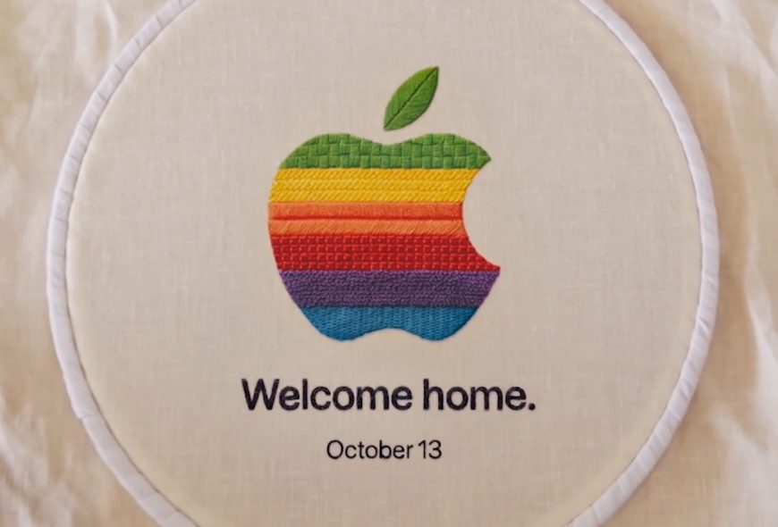 Bordado con logo de manzana multicolor y texto Welcome home y October 13 en un aro de bordar.