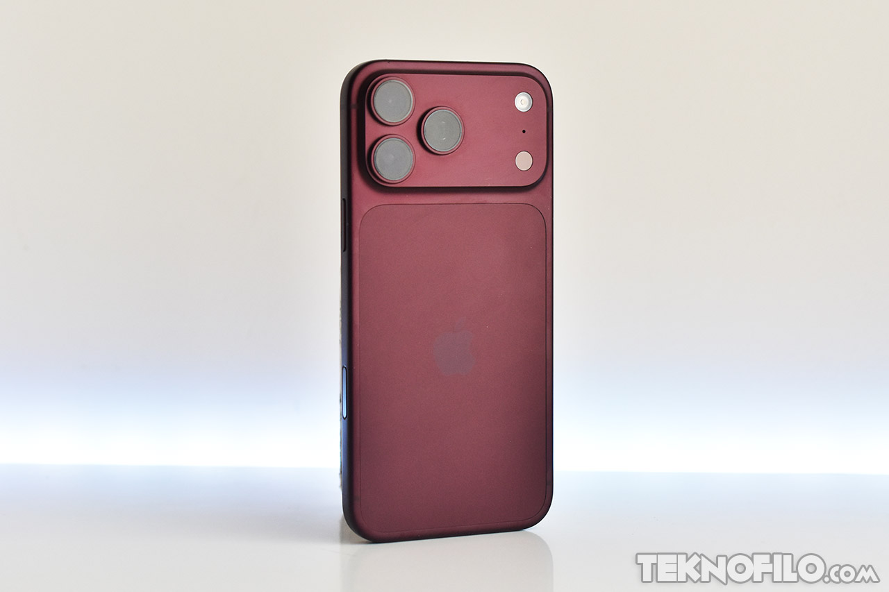 Teléfono móvil rojo oscuro, vista posterior, con tres cámaras y diseño moderno.