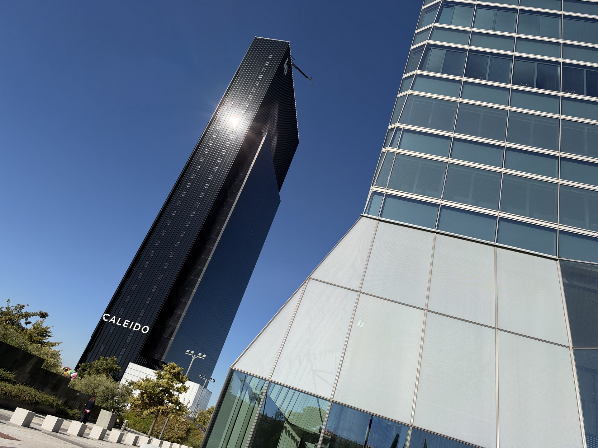 Edificios modernos con cielo azul en Madrid, destacando la torre Caleido y arquitectura contemporánea.