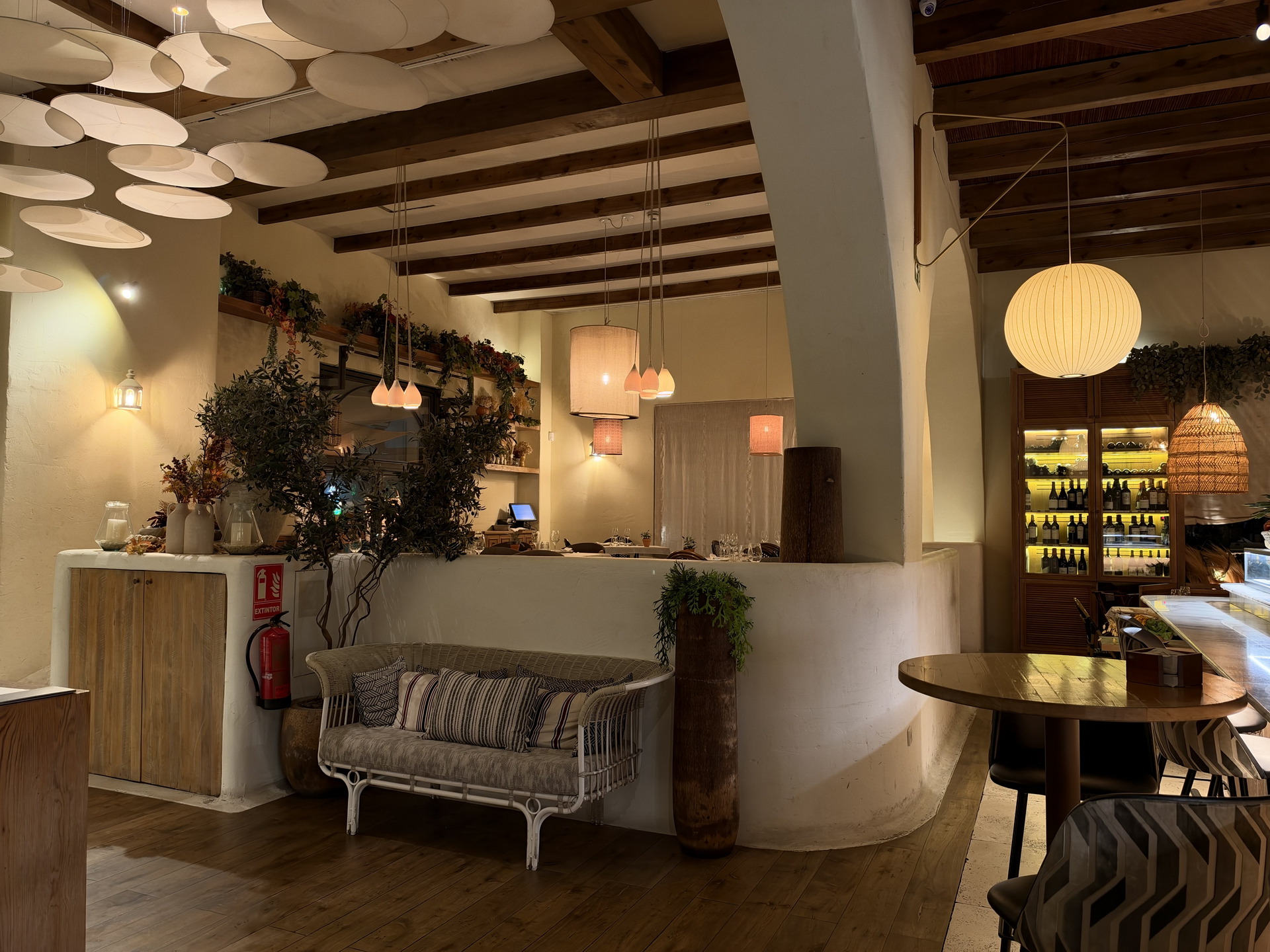 Acogedor restaurante de estilo rústico con iluminación cálida, muebles de madera y decoración natural.