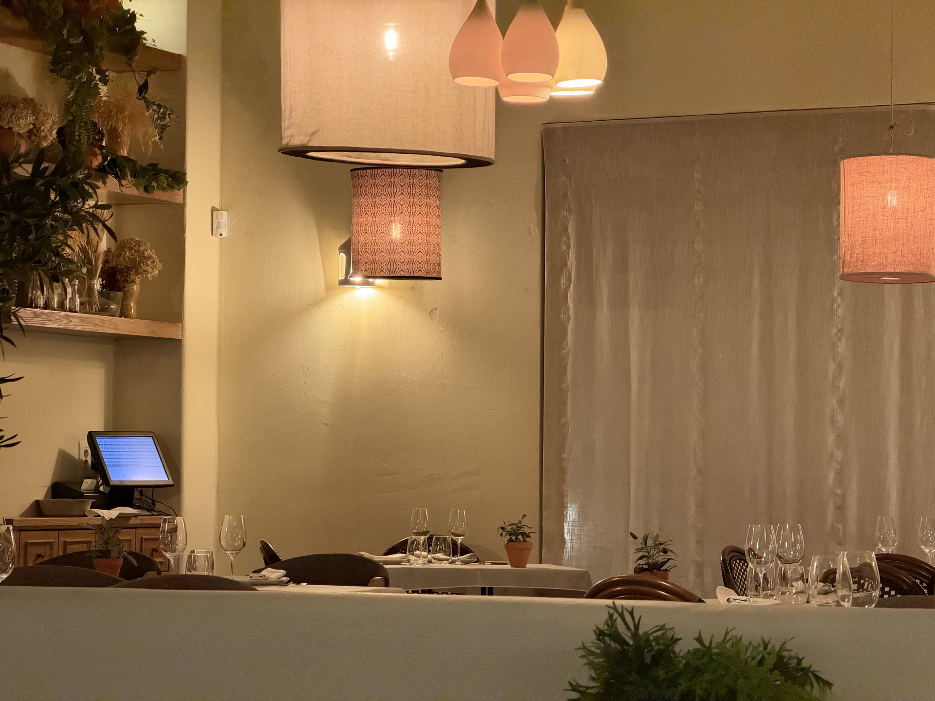 Restaurante elegante con iluminación cálida y mesas con copas de vino, creando un ambiente acogedor y sofisticado.