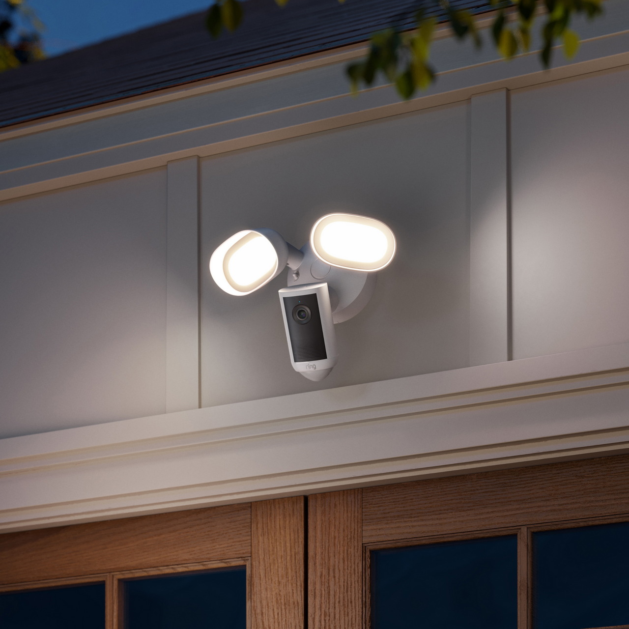 Ring Floodlight Camera 4K Plus instalada junto a una entrada con sus dos focos encendidos