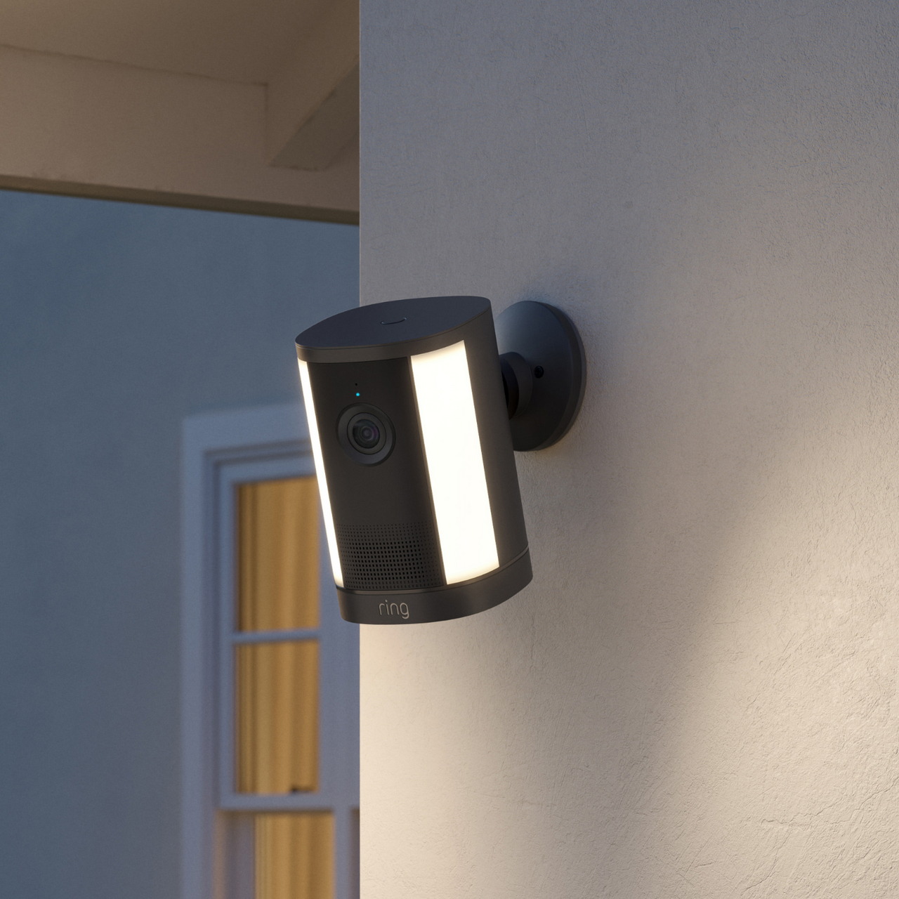 Ring Spotlight Camera 4K Plus negra con su foco encendido en una entrada