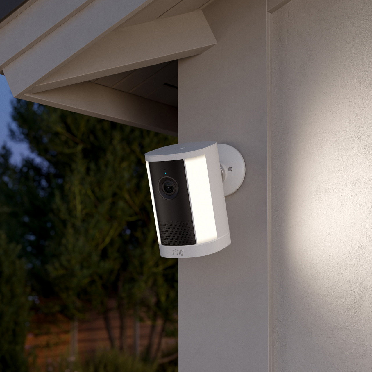 Ring Spotlight Camera 4K Plus blanca instalada junto a un acceso exterior